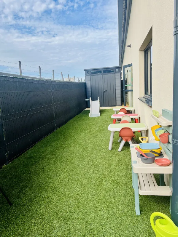 Espace de jeux extérieur avec cuisine en bois de la micro-crèche Tétine et Berlingot à Belleville-en-Beaujolais