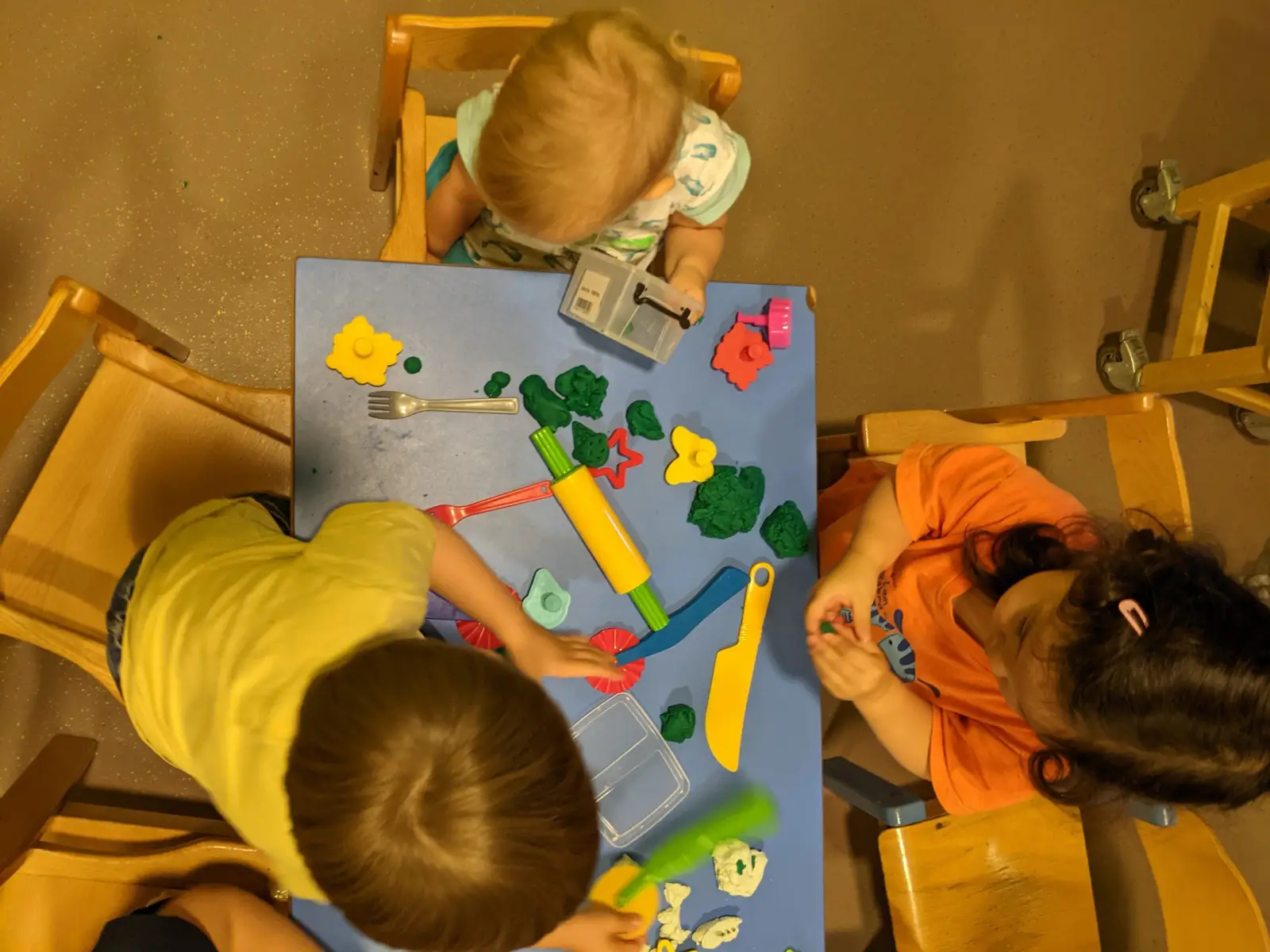 Atelier pâte à modeler autour d'une table à la crèche parentale Petit Némo à Villeurbanne