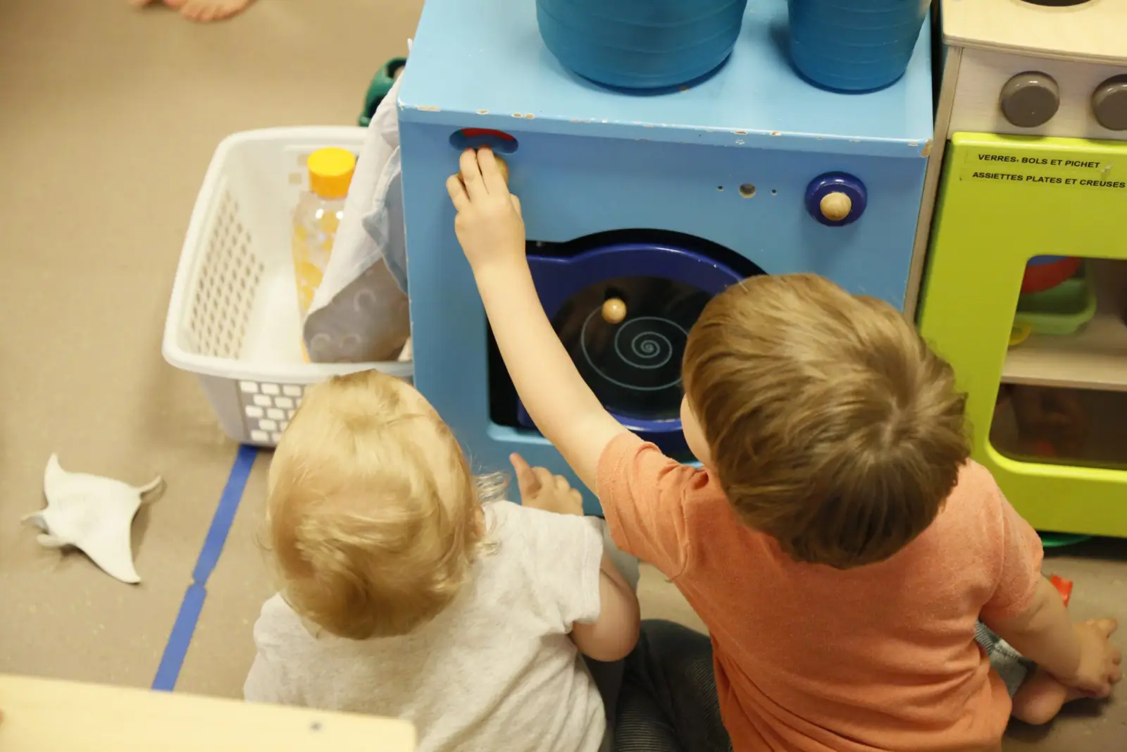 Jeu d'imitation avec une cuisine en bois à la crèche Petit Némo Villeurbanne