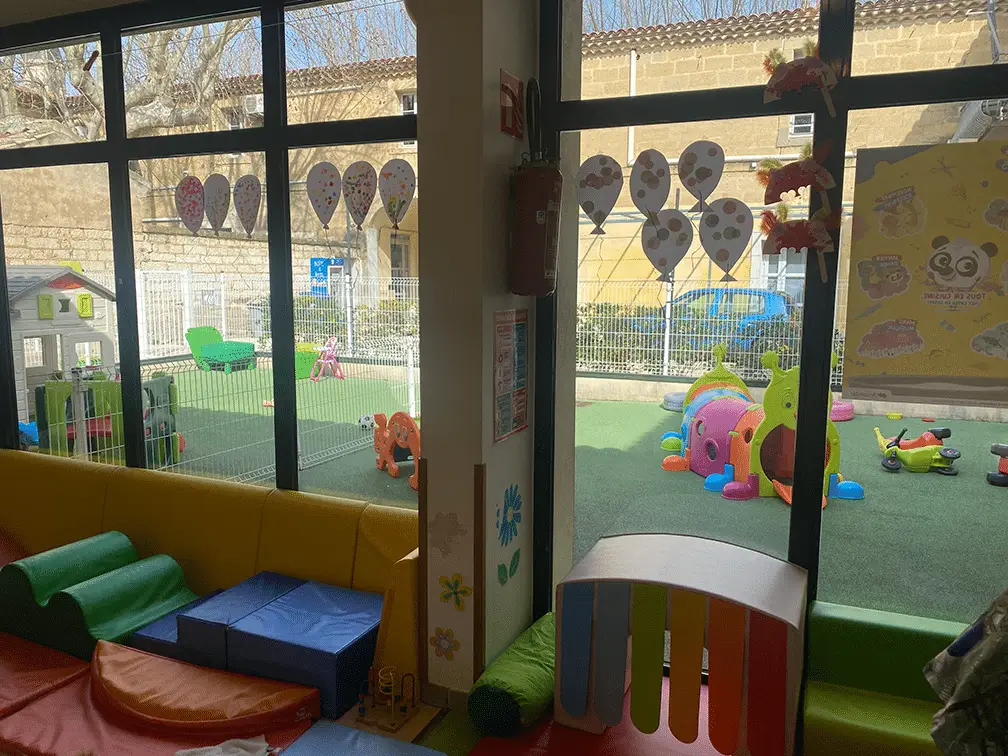 Espace de motricité et vue sur la cour de jeux extérieure aux Petits Lutins, Le Cailar