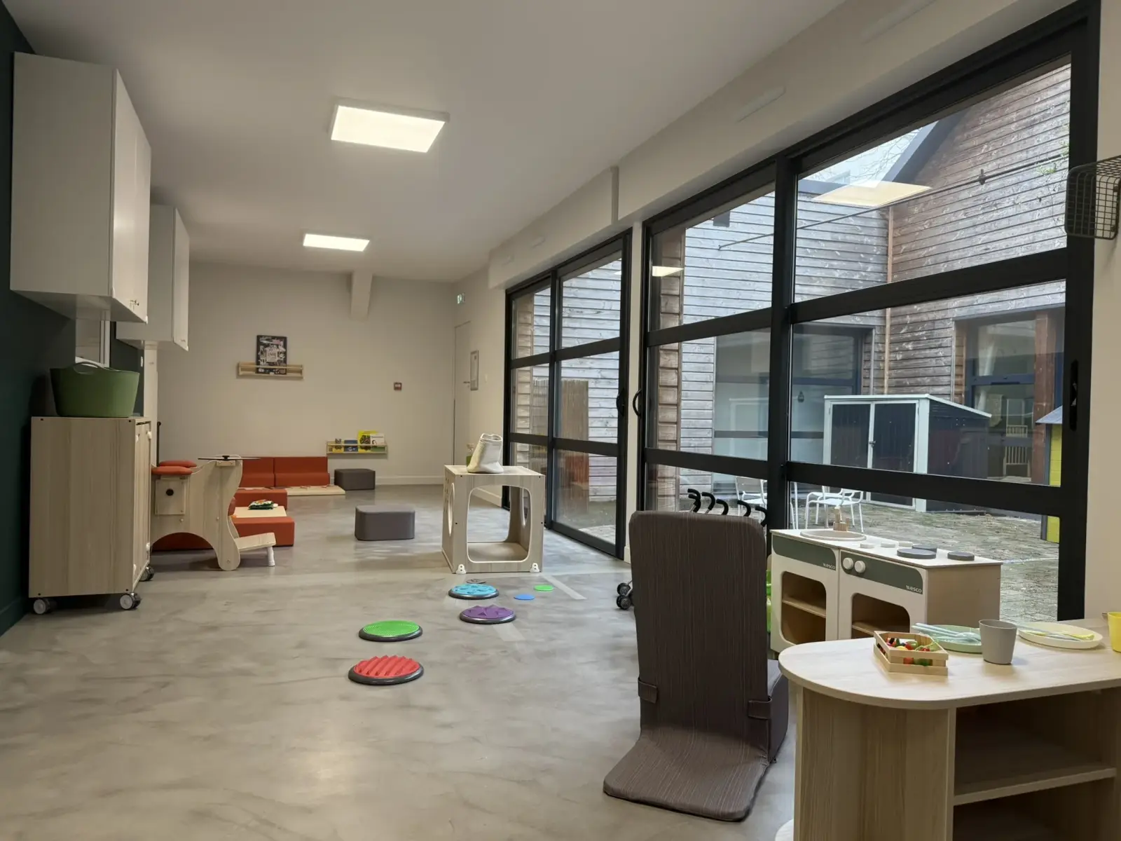 Grande salle de vie baignée de lumière à la micro-crèche Chez Minido à Nantes