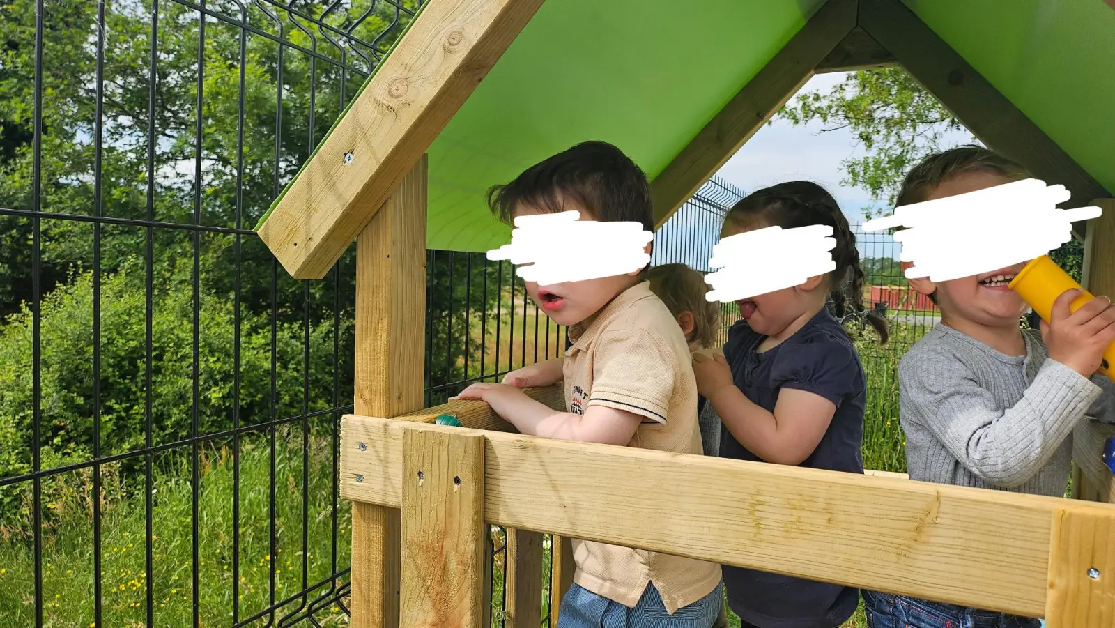 Enfants jouant dans la cabane en bois du jardin de la micro-crèche Lily and Wolf de Campbon
