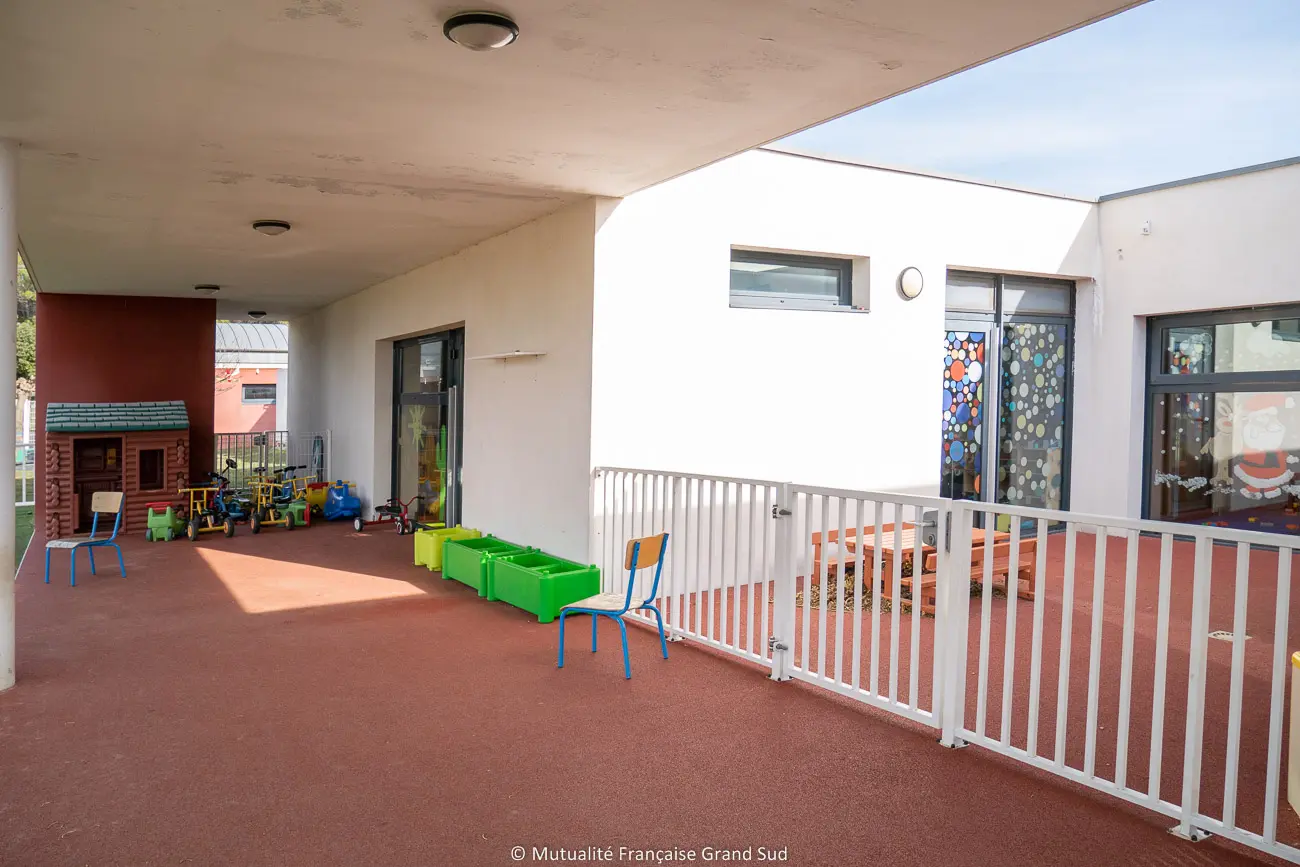 Terrasse couverte et espace de jeux de la crèche Los Pequelets
