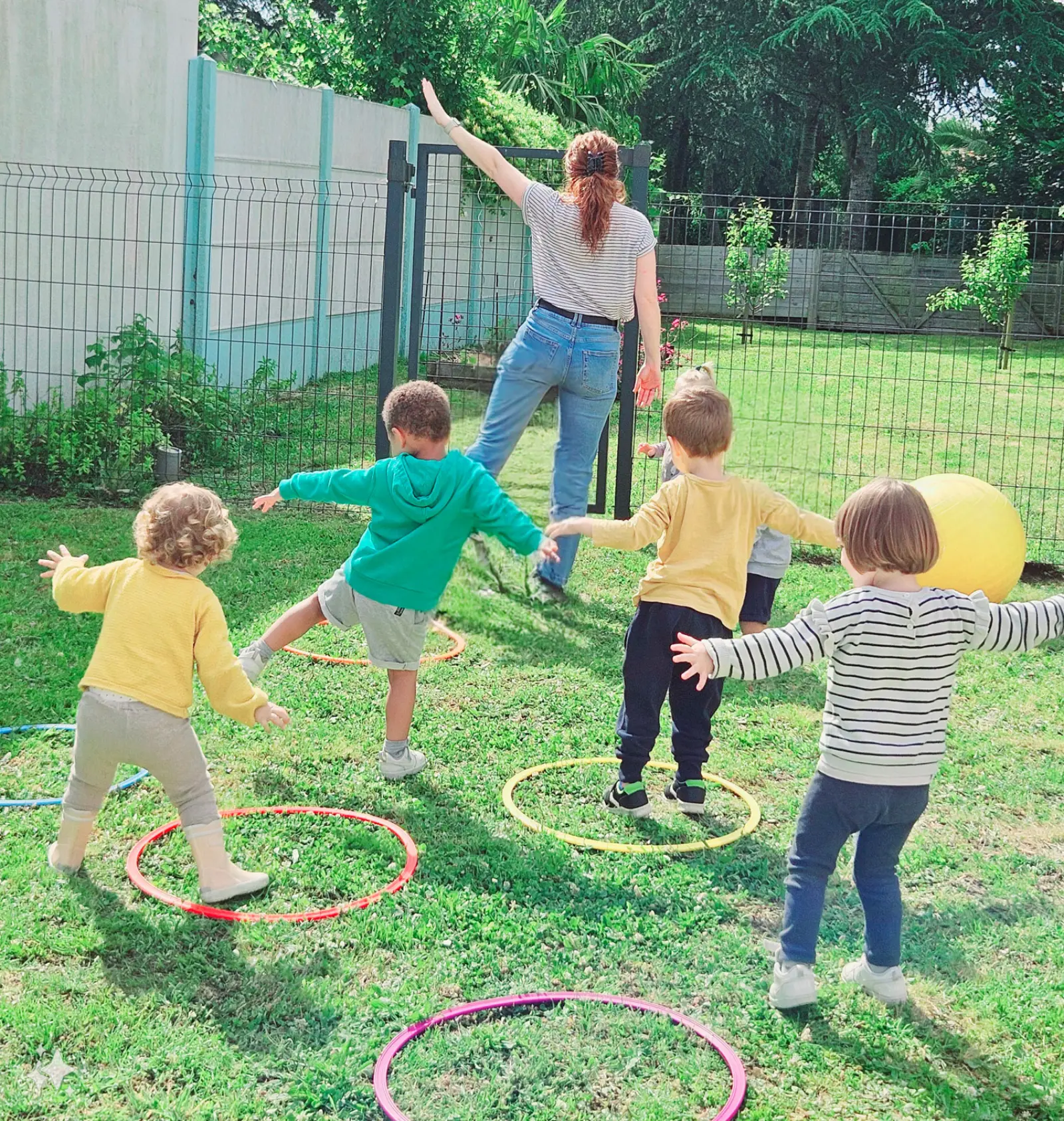 Séance de motricité en extérieur avec cerceaux à la micro-crèche de Bouguenais