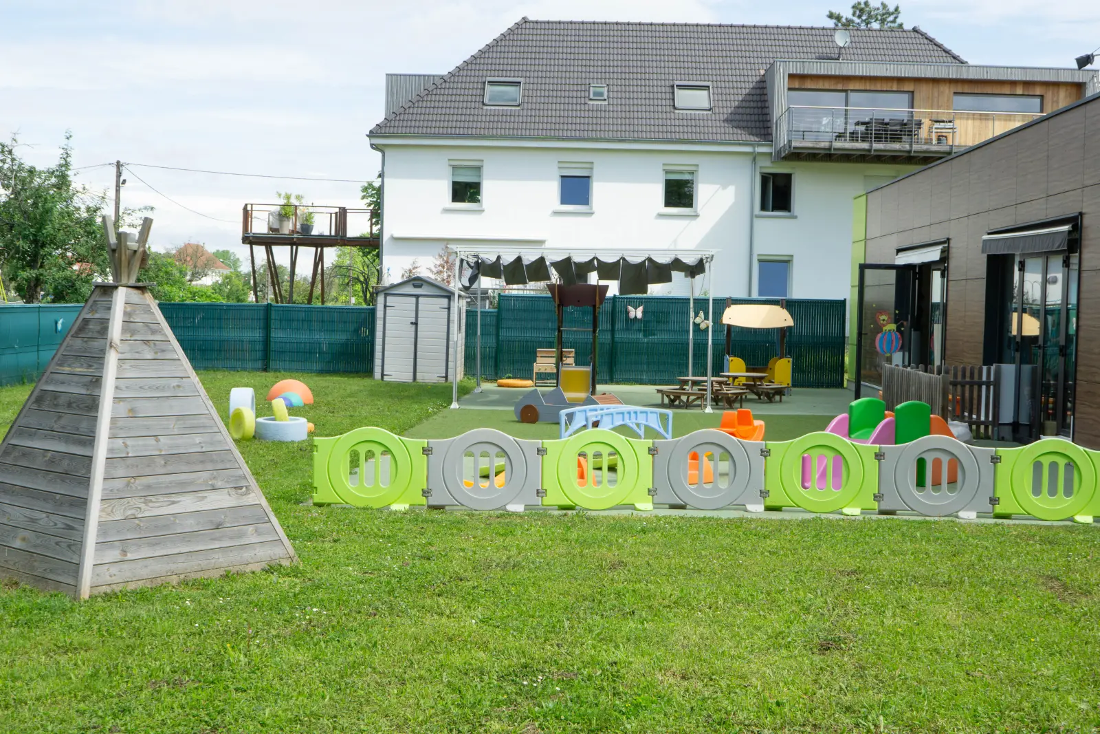 Tipi en bois sur la pelouse de la crèche Kembs