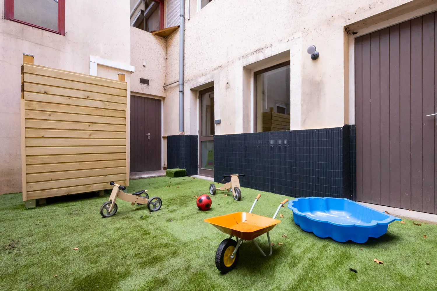 Espace extérieur avec gazon et jeux de la micro-crèche de Mâcon