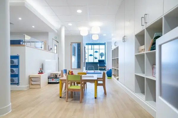 Grande salle d'activités avec bibliothèque de la micro-crèche Saint-Ambroise à Paris 11e