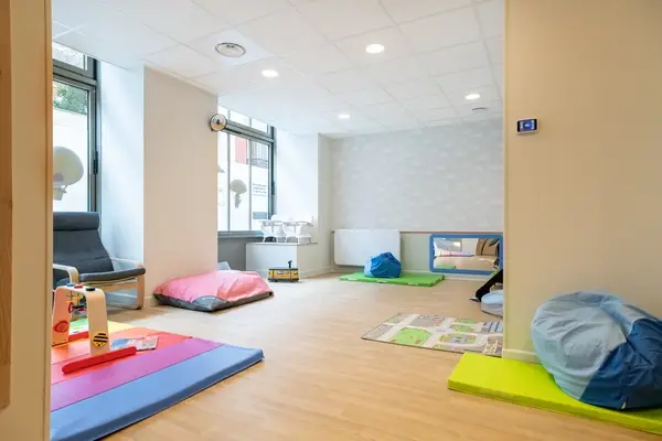 Espace de repos et d'éveil avec tapis de la micro-crèche à Paris 11e