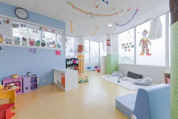Grande salle avec guirlandes et coin repos à la micro-crèche Les Bébés Explorateurs de Grenoble