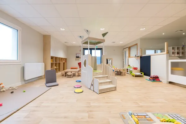 Salle principale avec structure en bois et parcours de motricité à la crèche Les Explorateurs de Vertou