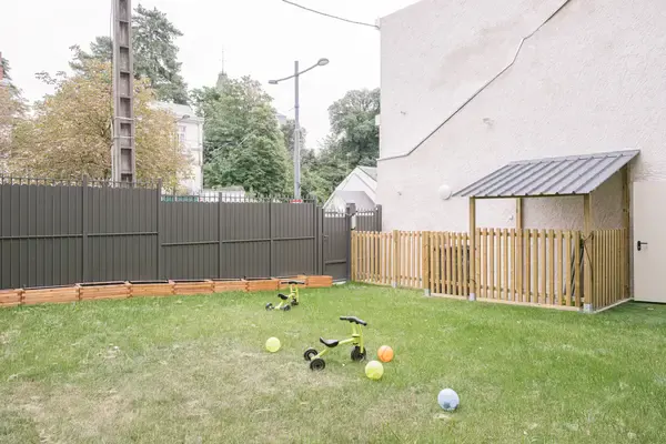Jardin extérieur avec bac à sable et tricycles à la crèche Les Explorateurs de Tours Saint-Symphorien