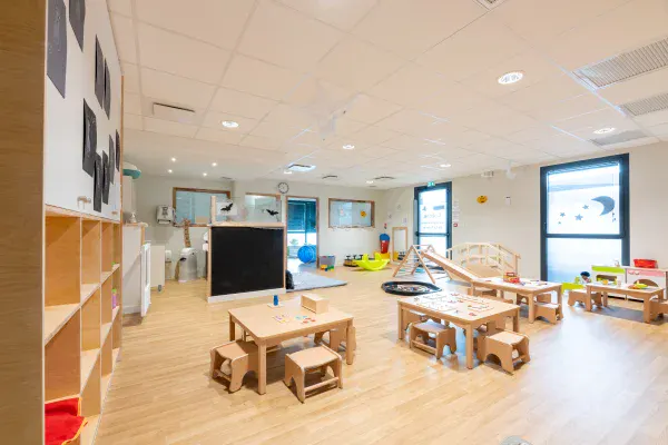 Grande salle de jeux avec tables et matériel Pikler à la crèche Les Explorateurs de Rennes La Poterie