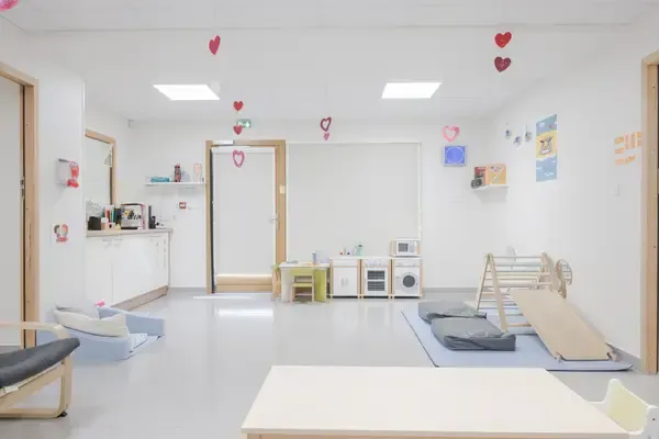 Salle de jeux colorée avec dinette et toboggan à la micro-crèche Les Petits Flocons de Montagny-les-Lanches