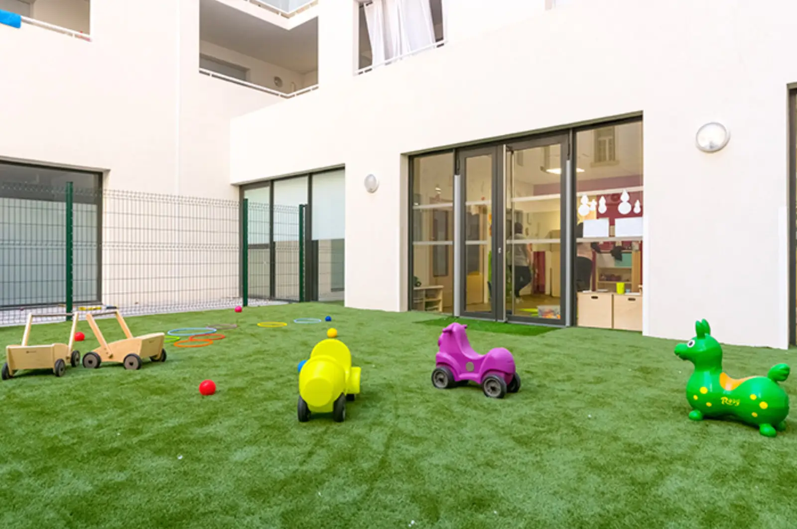 Cour extérieure engazonnée de la micro-crèche Les Malicieux de Mazenod à Marseille