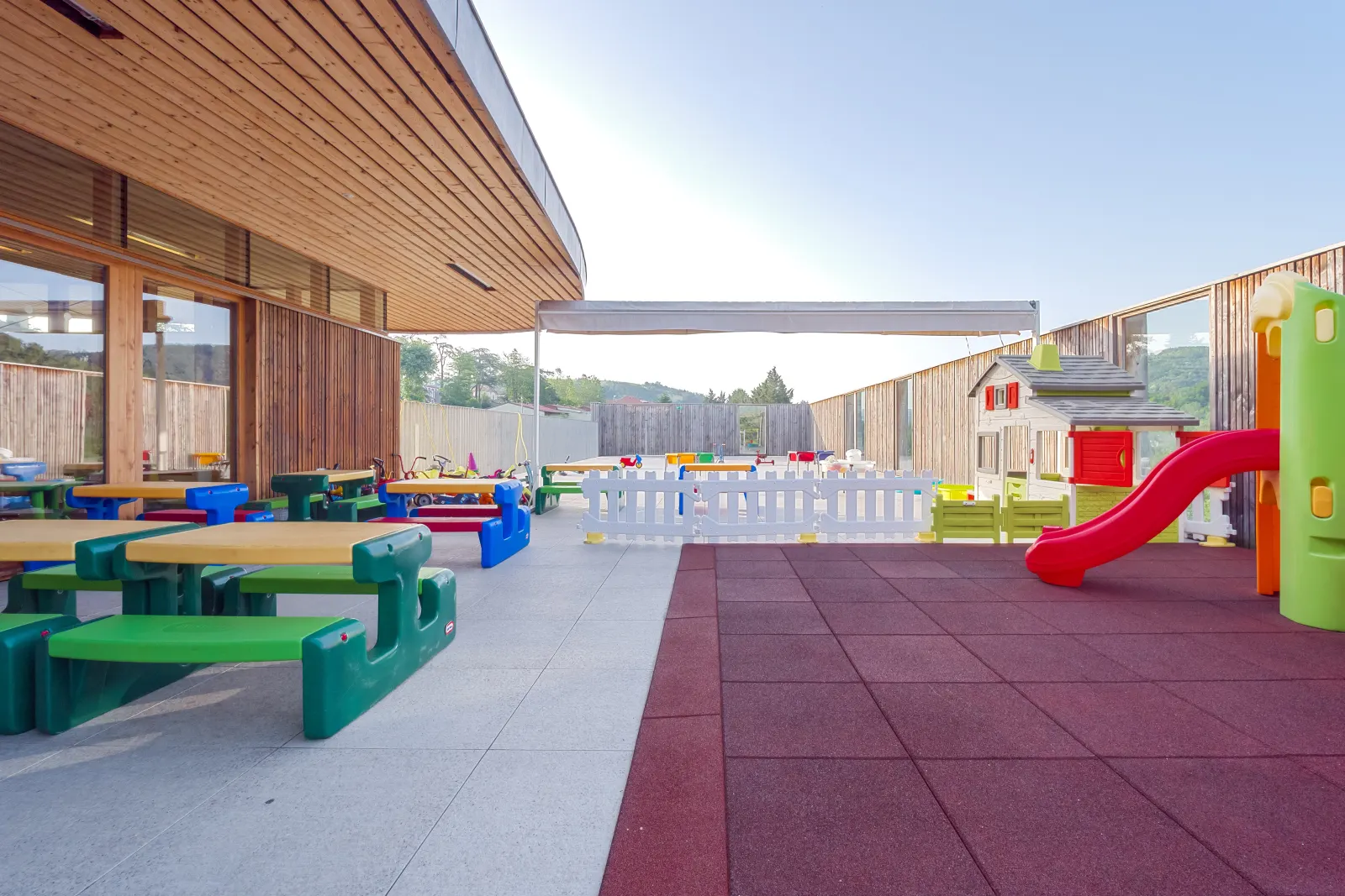 Cour extérieure avec toboggan et espace pique-nique de la crèche Le Jardin des Écureuils