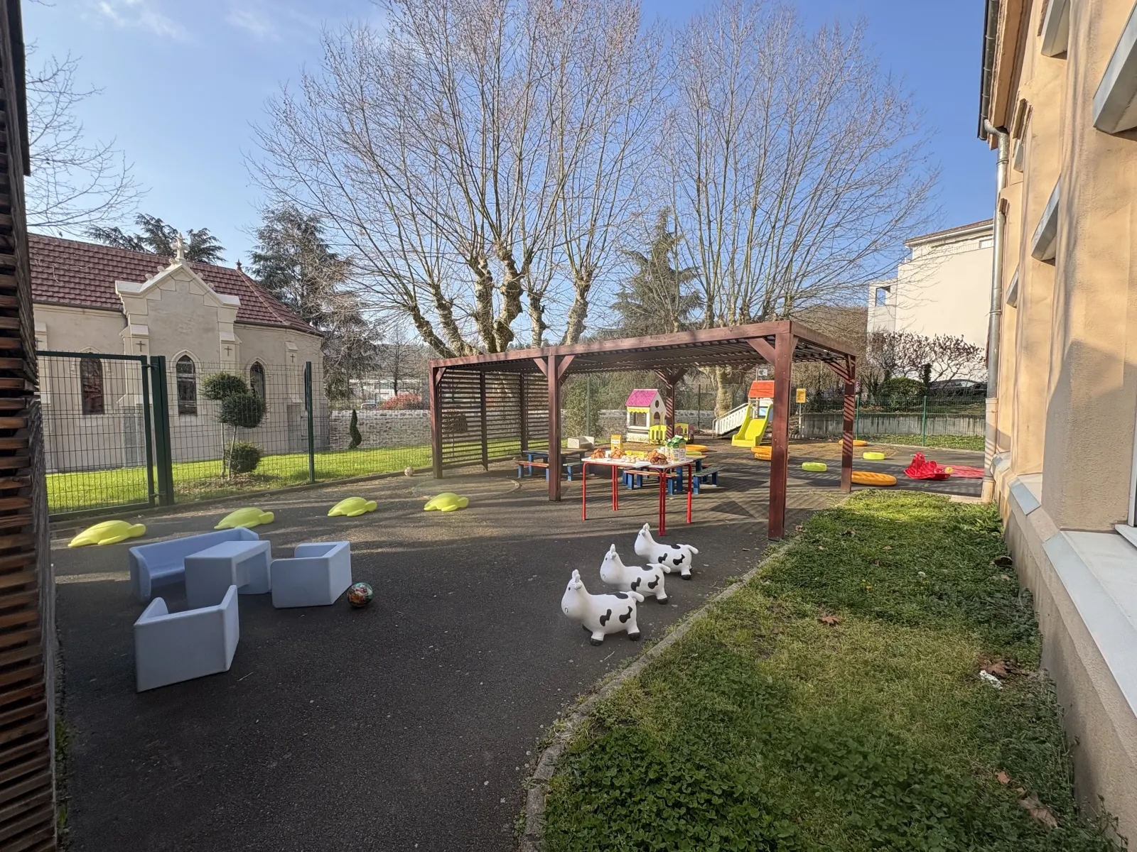 Cour extérieure couverte avec jeux de la crèche La Cachette des Écureuils à La Fouillouse