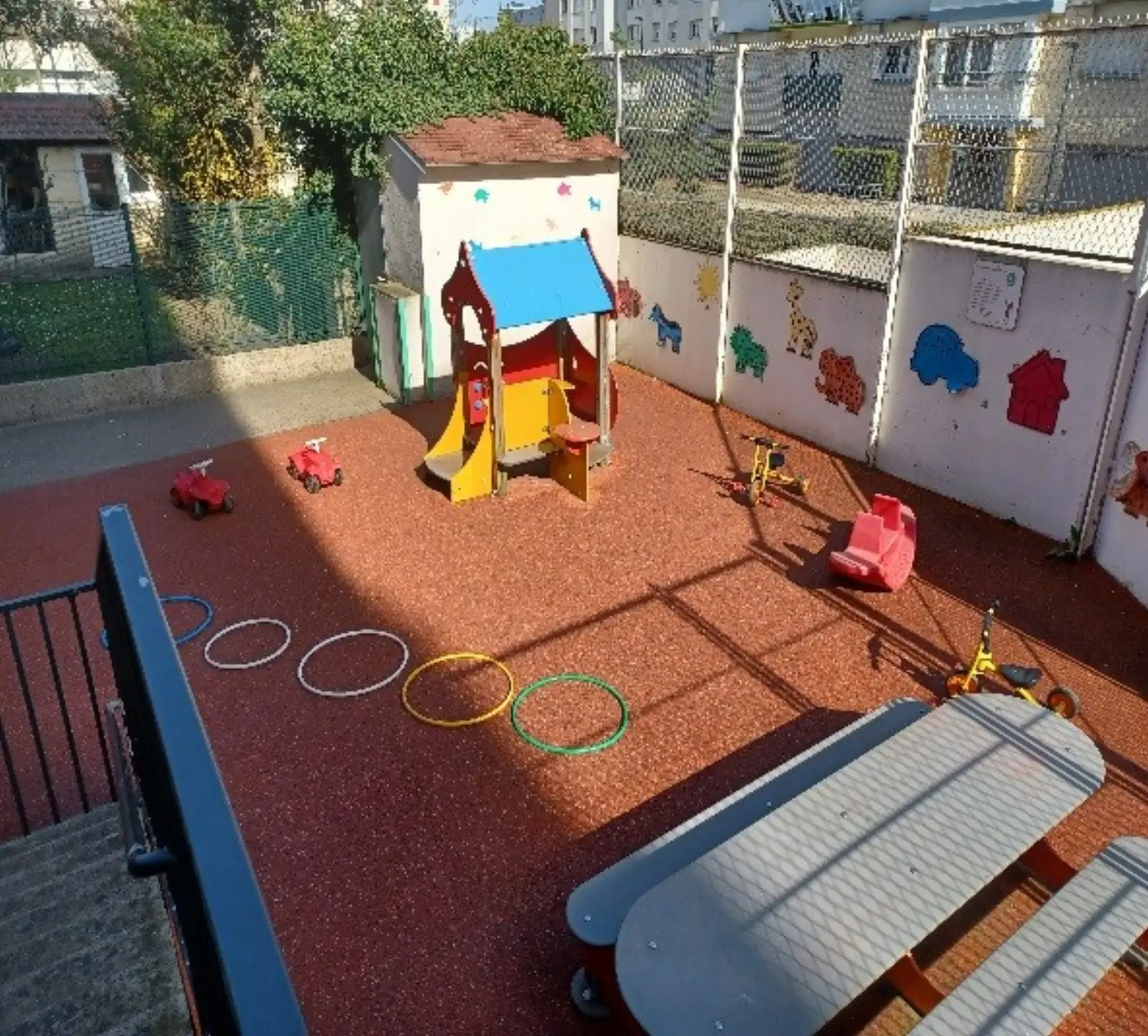 Cour extérieure avec jeux et tricycles de la crèche Les Petits Diables