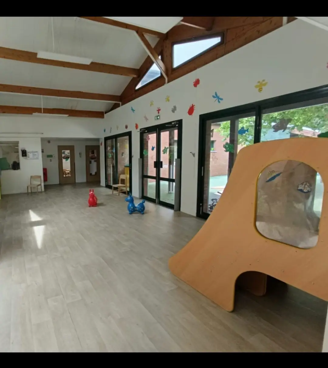 Grande salle à charpente bois apparente de la crèche Le Blé en Herbe à Argenteuil