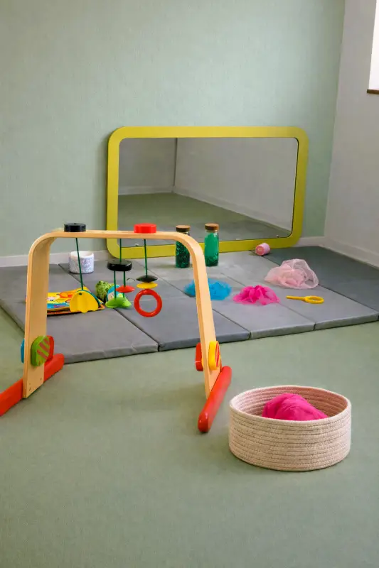 Coin éveil sensoriel avec miroir et jeux de manipulation à la micro-crèche Au Bonheur des Chérubins à Eckbolsheim