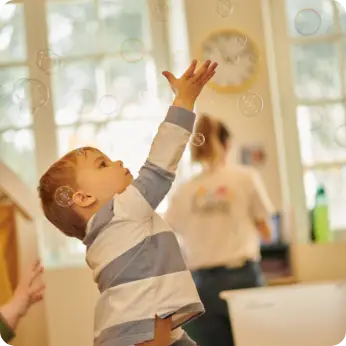 Enfant jouant avec des bulles de savon à la micro-crèche de Rennes
