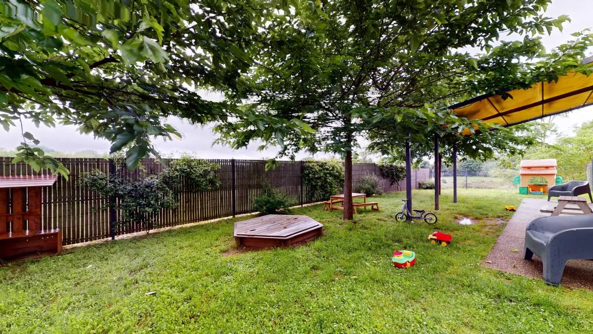 Jardin extérieur avec bac à sable de la micro-crèche Les Marmottons à Champniers