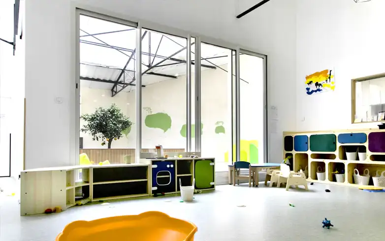 Grande salle de jeux lumineuse à la micro-crèche Les Dames