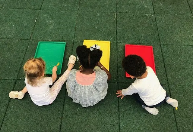 Enfants jouant ensemble dans l'espace extérieur de la micro-crèche
