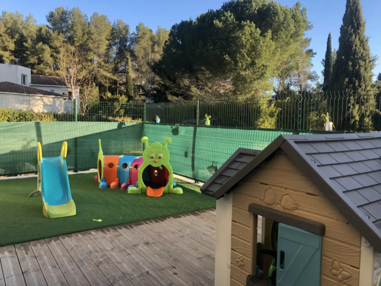 Jardin extérieur avec toboggan et maisonnette à la micro-crèche L'Ilot des Chérubins de Saint-Clément-de-Rivière