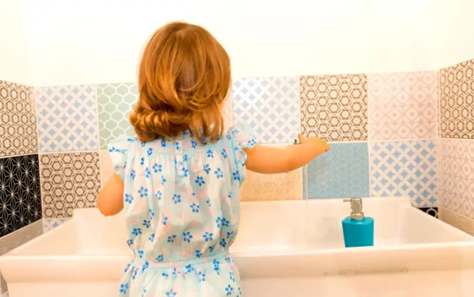 Un enfant se lave les mains dans la salle de bain à la micro-crèche Romulus et Rémus
