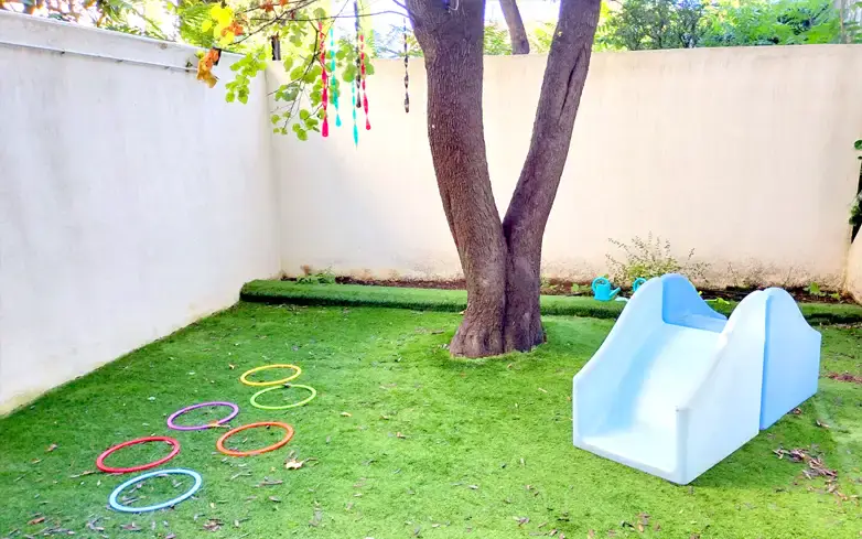 Jardin extérieur ombragé avec jeux de la micro-crèche Zola à Marseille
